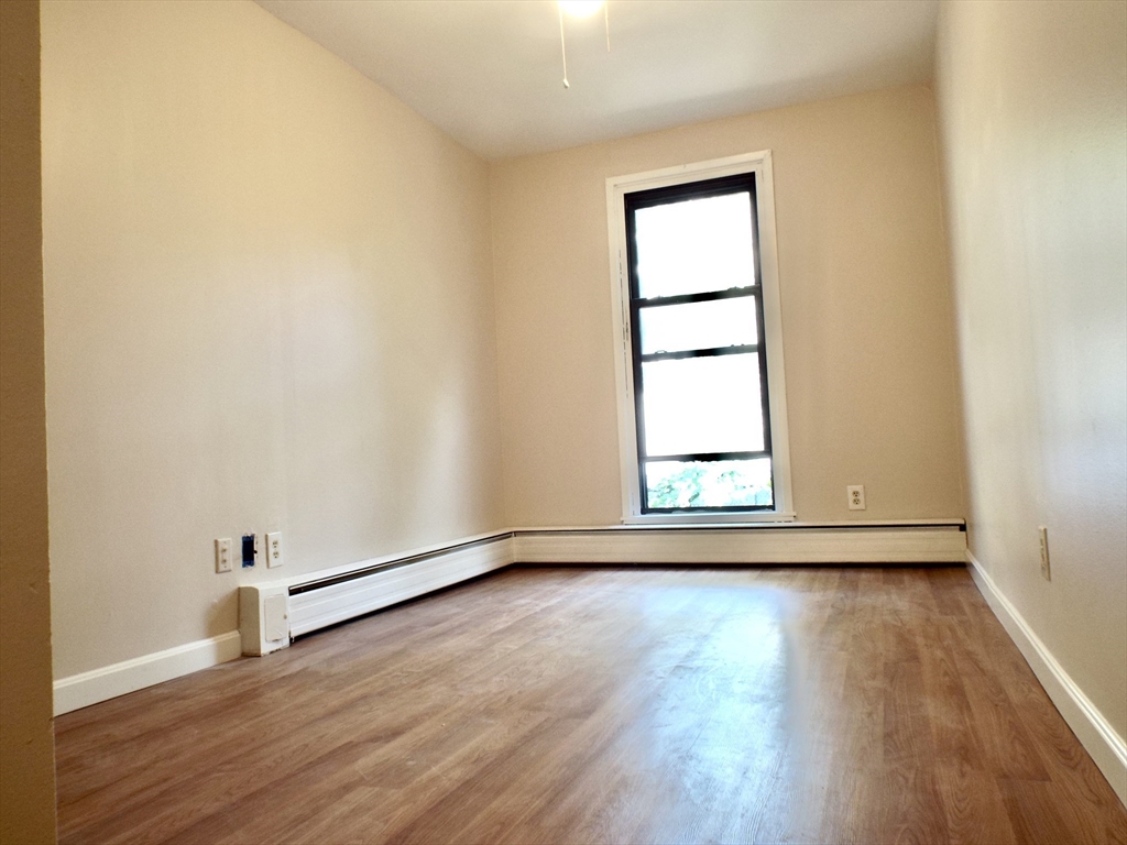 32 Juniper Street, Unit 98 Brookline, MA 02445 - Photo 9 of 17 an empty room with wooden floor and windows