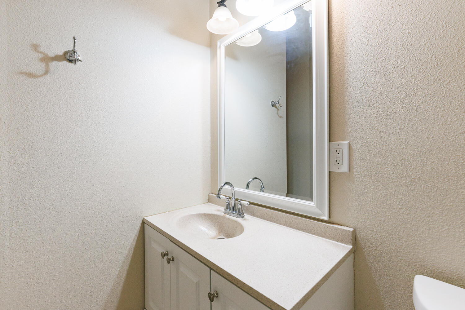 211 Chestnut Street Idalou, TX 79329 - Photo 21 of 31 a bathroom with a sink vanity and a mirror