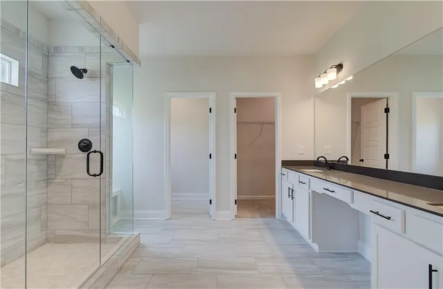 a large bathroom with a glass shower door and a sink