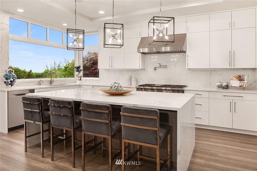 8431 Ridge Road Medina, WA 98039 - Photo 14 of 40 a kitchen with stainless steel appliances a white stove top oven and white cabinets