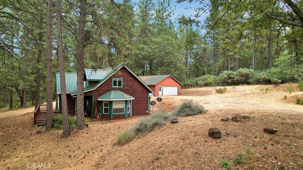 a wooden house with a yard and large trees