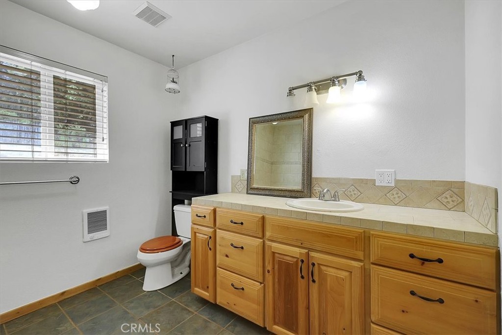 13233 Dixon Hill Road Oregon House, CA 95962 - Photo 26 of 60 a spacious bathroom with a granite countertop sink mirror and toilet