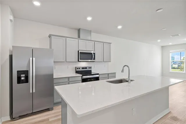 a kitchen with kitchen island granite countertop a sink and wooden cabinets
