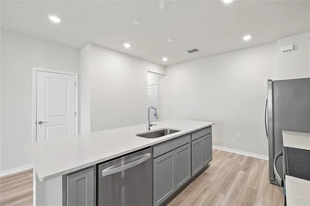 a kitchen with stainless steel appliances a refrigerator sink and microwave