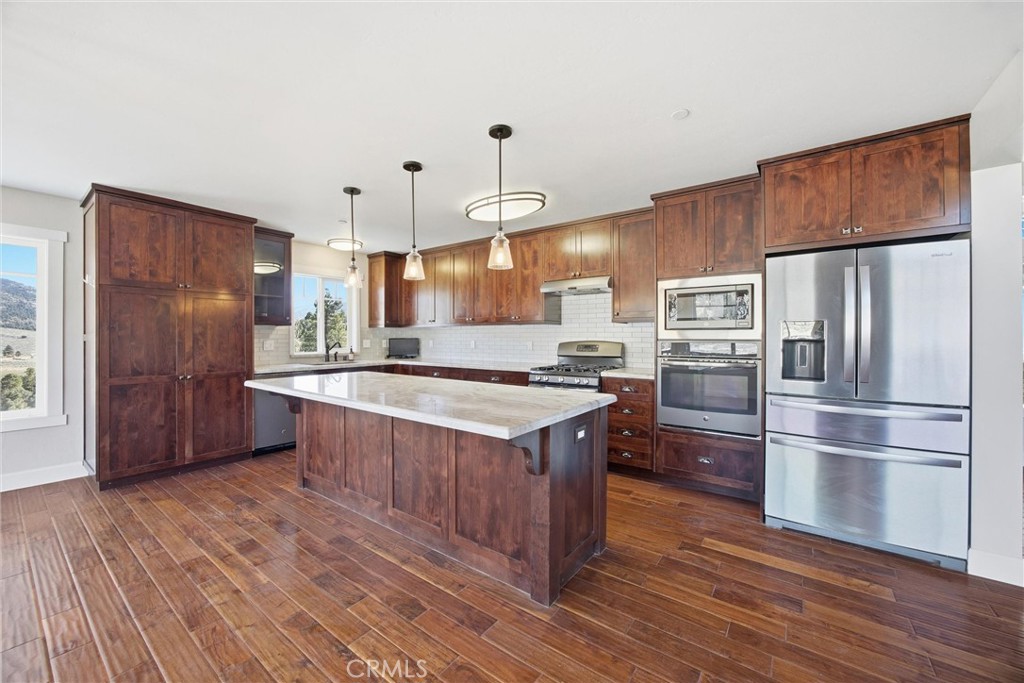 9401 Whispering Pines Road Frazier Park, CA 93225 - Photo 13 of 49 a kitchen with stainless steel appliances granite countertop a refrigerator a sink dishwasher a stove and a wooden floor