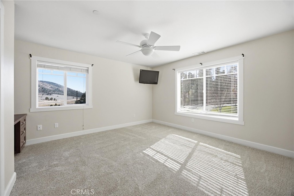 9401 Whispering Pines Road Frazier Park, CA 93225 - Photo 25 of 49 an empty room with windows and ceiling fan