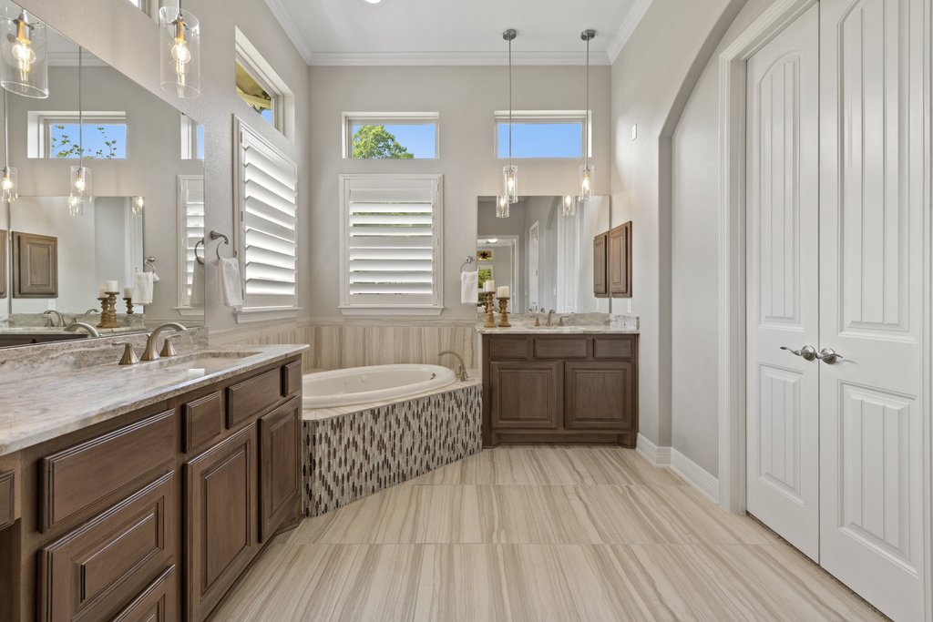 108 Berry Cove Georgetown, TX 78628 - Photo 19 of 39 a bathroom with a double vanity sink a large mirror and a bathtub