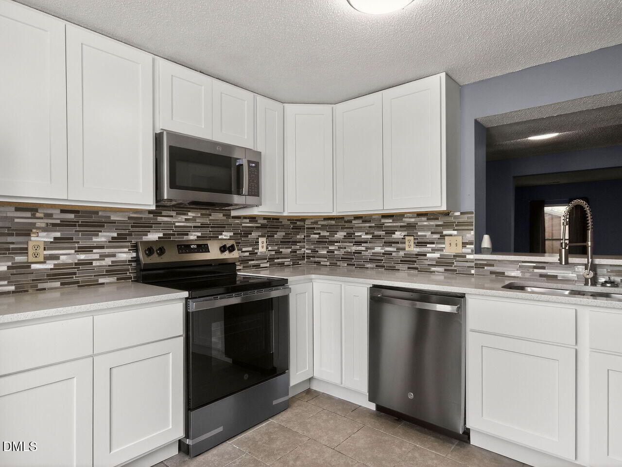 4333 Halliwell Drive Raleigh, NC 27606 - Photo 2 of 31 a kitchen with white cabinets granite counter tops and a stove