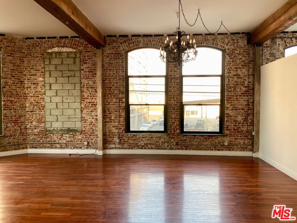 652 Mateo Street, Unit 202 Los Angeles, CA 90021 - Photo 3 of 9 a view of a room with wooden floor and chandelier
