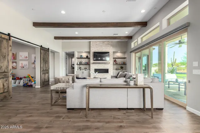 a living room with furniture wooden floor and a large window