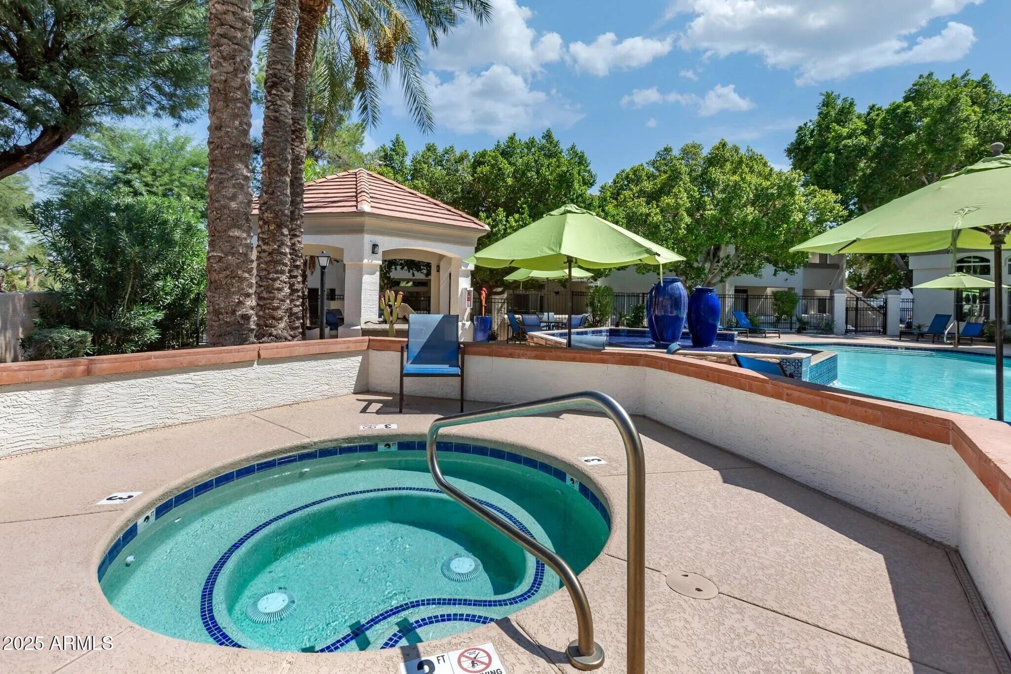 5102 East Piedmont Road, Unit A1 Phoenix, AZ 85044 - Photo 8 of 8 a backyard with table and chairs under an umbrella