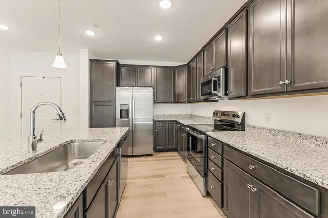 a kitchen with granite countertop a stove and a microwave