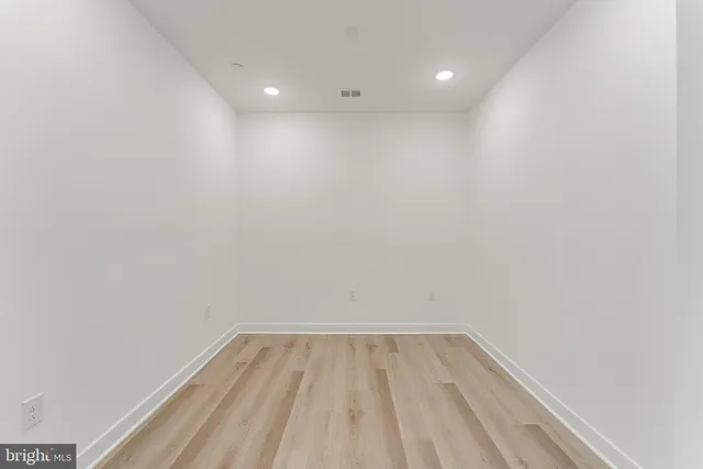 a view of empty room with wooden floor and windows