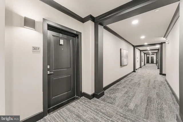 a living room with couches and painting on the wall with wooden floor