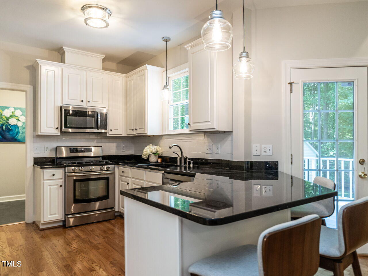 12205 Glenlivet Way Raleigh, NC 27613 - Photo 13 of 37 a kitchen with stainless steel appliances granite countertop a stove a sink and a microwave