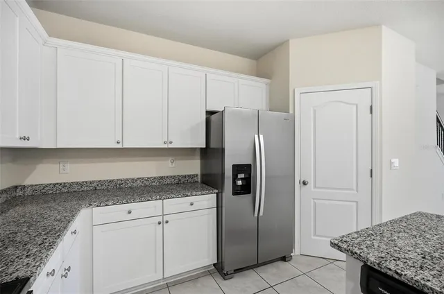 a kitchen with stainless steel appliances granite countertop a refrigerator and cabinets