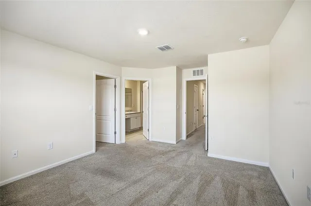 an empty room with closet and windows