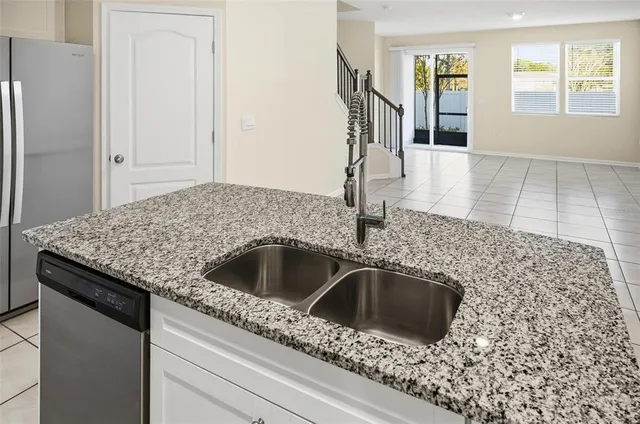 a kitchen with granite countertop a sink and a stove