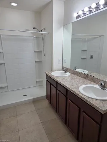 a bathroom with a granite countertop sink mirror and shower