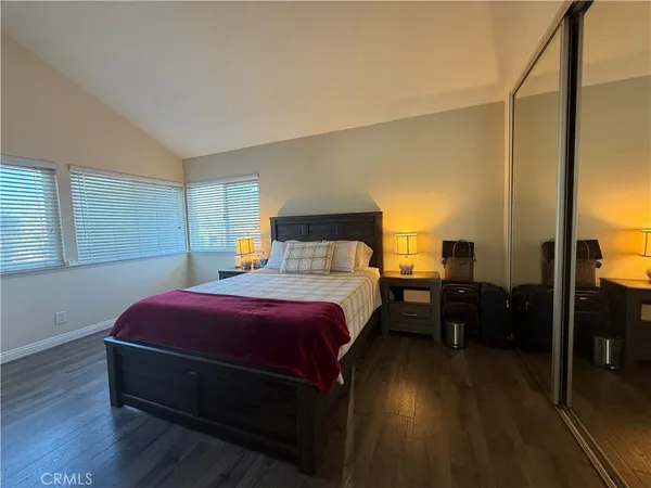 a spacious bedroom with a bed and wooden floor