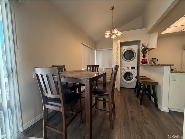 a view of a dining room with furniture a chandelier and wooden floor
