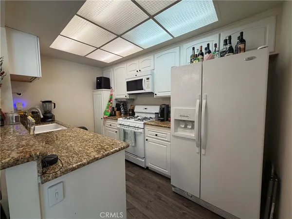 a kitchen with refrigerator cabinets and wooden floor