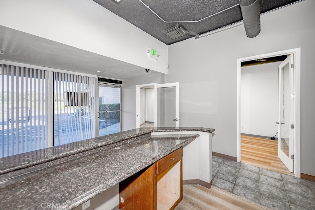 24609 Arch Street Newhall, CA 91321 - Photo 14 of 22 a kitchen with granite countertop a sink and a wooden floor