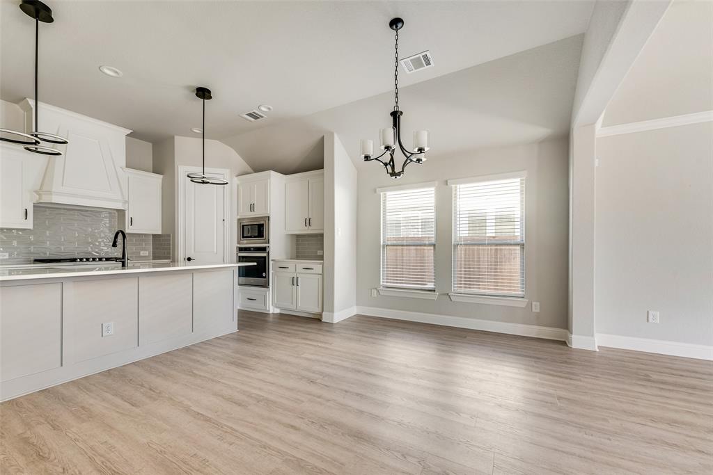 1905 Graham Way Mansfield, TX 76063 - Photo 6 of 20 a open kitchen with stainless steel appliances granite countertop a stove a refrigerator a sink a center island and wooden floor