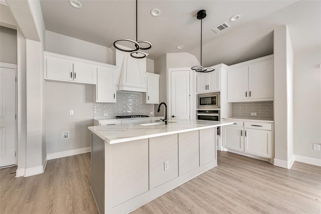 1905 Graham Way Mansfield, TX 76063 - Photo 8 of 20 a kitchen with white cabinets stainless steel appliances and wooden floor