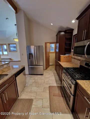 a kitchen with granite countertop a stove and cabinets