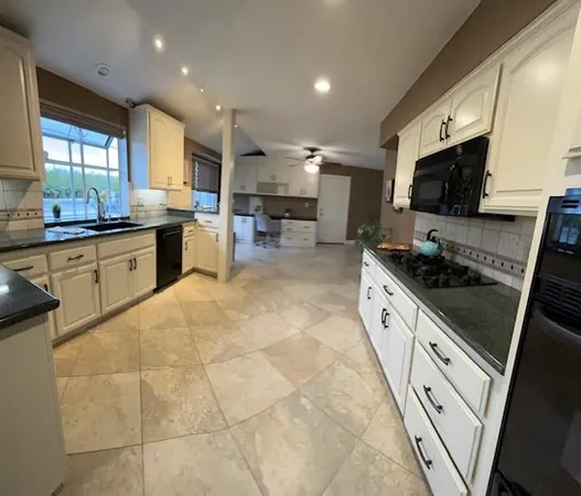 a large kitchen with stainless steel appliances granite countertop a stove and a sink