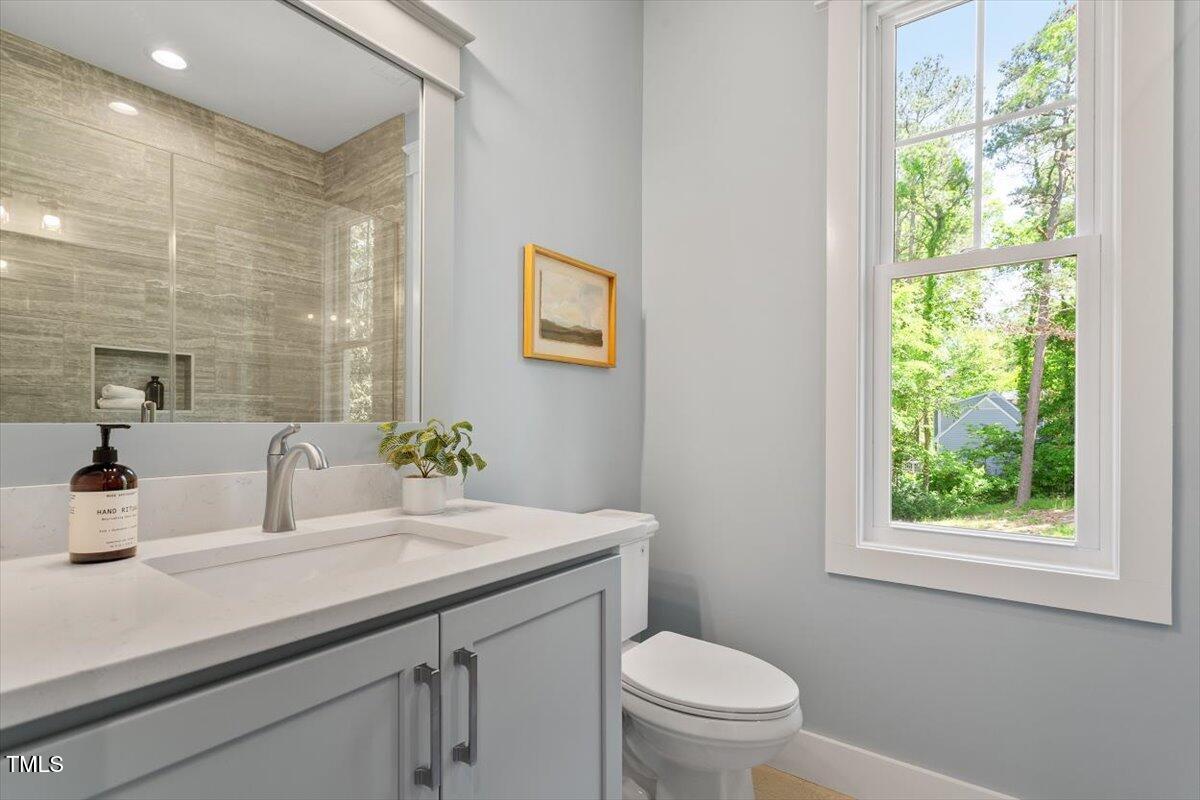 3932 Old Chapel Hill Road Durham, NC 27707 - Photo 34 of 46 a bathroom with a sink a toilet and a mirror