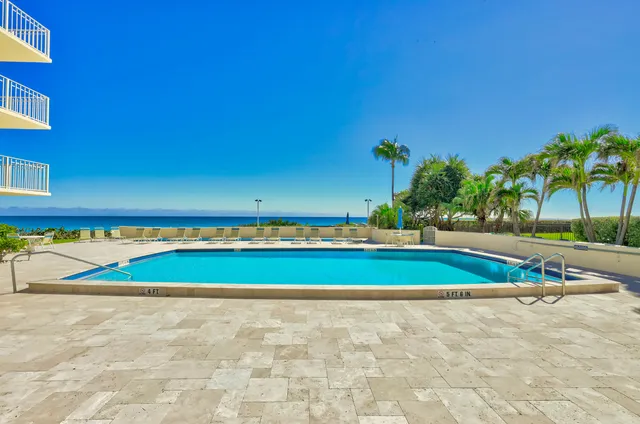 a view of a building with a swimming pool and a yard
