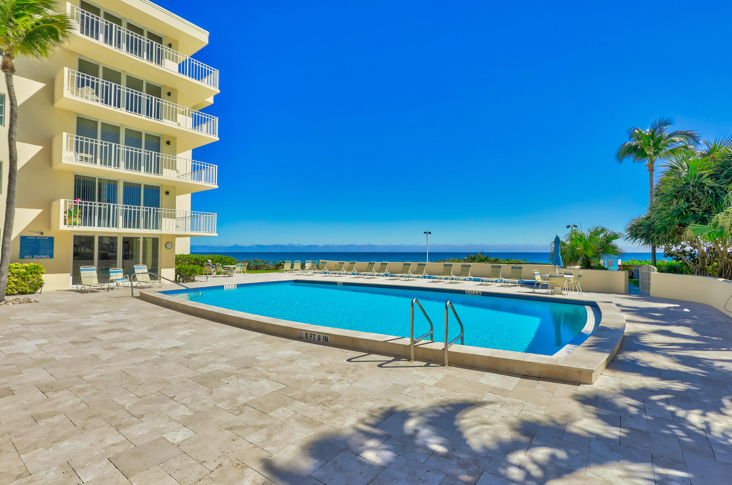 630 Ocean Drive, Unit 505 Juno Beach, FL 33408 - Photo 41 of 49 a view of a building with a swimming pool and a yard