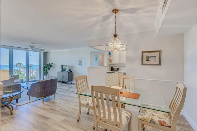 a view of a dining room with furniture a chandelier and wooden floor