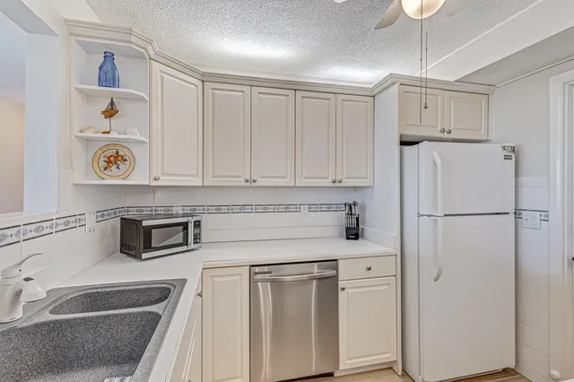 a kitchen with white cabinets and white appliances
