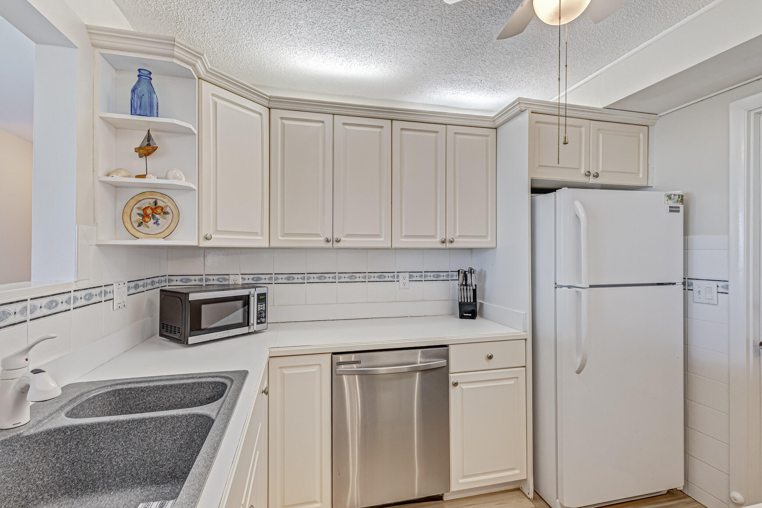 630 Ocean Drive, Unit 505 Juno Beach, FL 33408 - Photo 6 of 49 a kitchen with white cabinets and white appliances