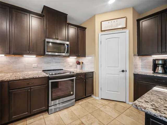 a kitchen with granite countertop a stove and a sink