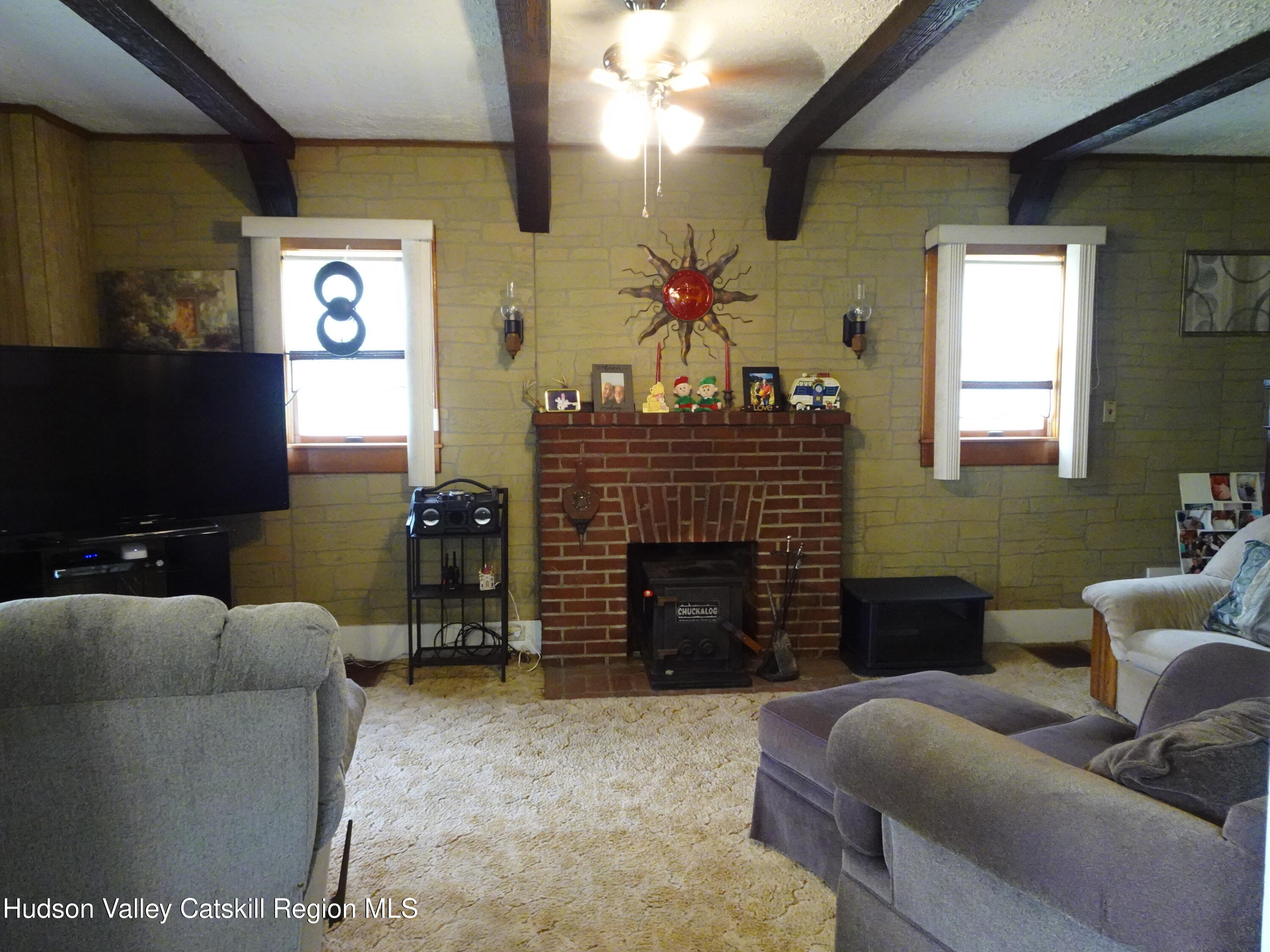 135 Millbrook Road Hudson, NY 12534 - Photo 12 of 40 a living room with furniture a flat screen tv and a fireplace