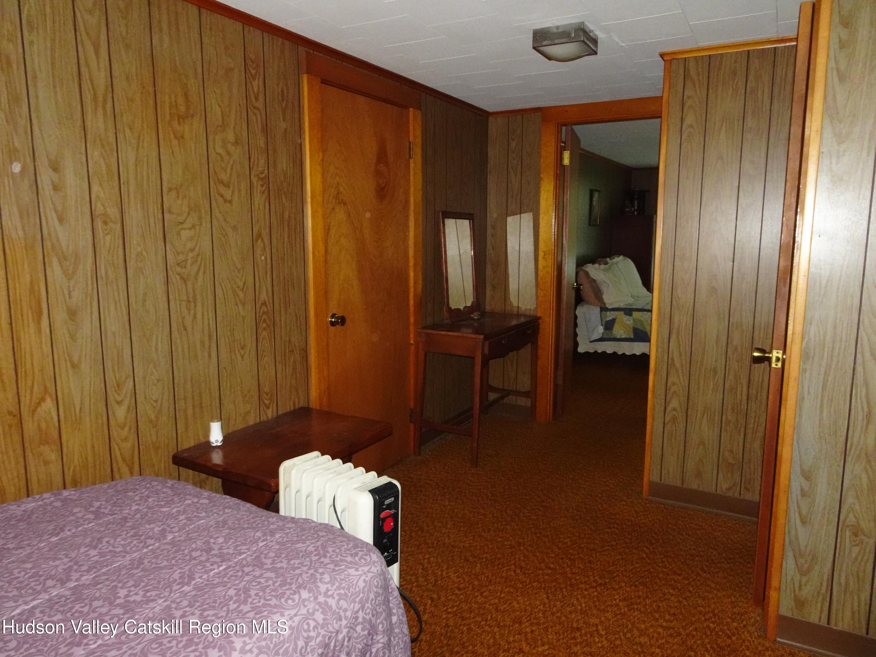 135 Millbrook Road Hudson, NY 12534 - Photo 29 of 40 a bedroom with a bed and a chandelier