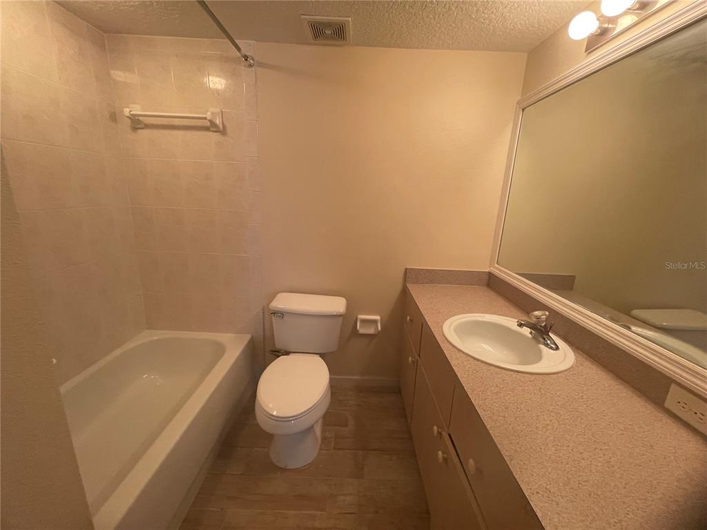 1122 South Pine Ridge Circle, Unit 1122 Sanford, FL 32773 - Photo 12 of 19 a bathroom with a sink a toilet and tub