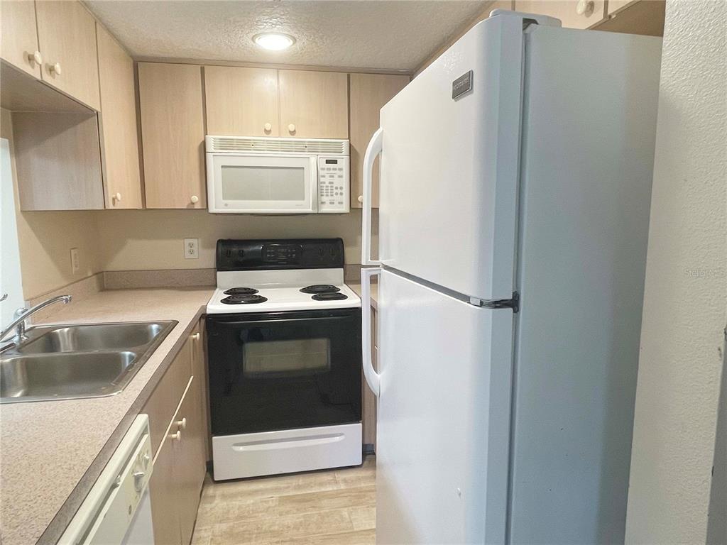 1122 South Pine Ridge Circle, Unit 1122 Sanford, FL 32773 - Photo 14 of 19 a kitchen with a refrigerator sink and stove
