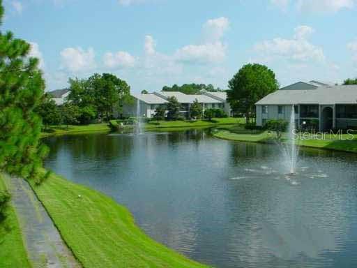1122 South Pine Ridge Circle, Unit 1122 Sanford, FL 32773 - Photo 18 of 19 a view of a lake with a yard
