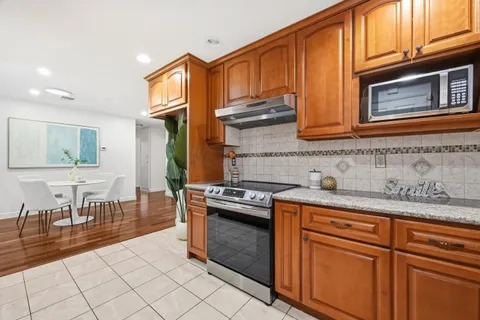a kitchen with stainless steel appliances granite countertop a stove a sink and a microwave