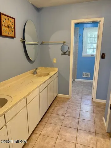 a bathroom with a granite countertop sink a mirror and a shower