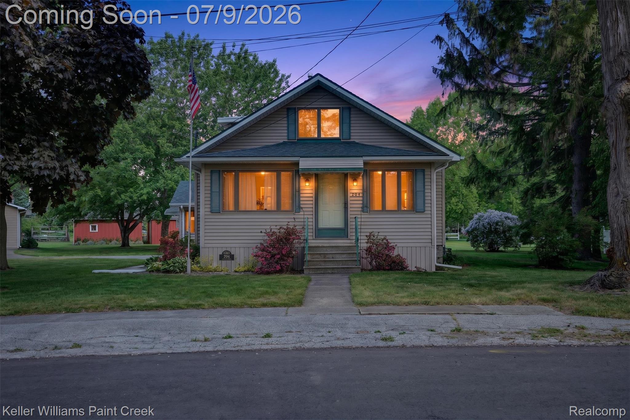 204 Russell Road Kawkawlin, MI 48631 - Photo 70 of 82 Siding exterior with a gable roof, featuring a concrete walkway, mature landscaping, and front-facing windows with shutters