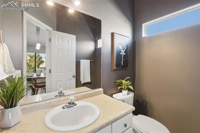 a bathroom with a toilet sink and mirror