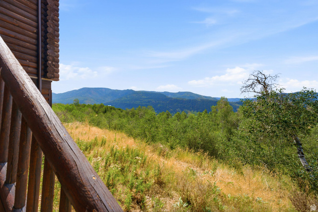 5404 Mountain View Road Coalville, UT 84017 - Photo 4 of 50 Log-sided exterior with a wooden railing and a mountainous backdrop