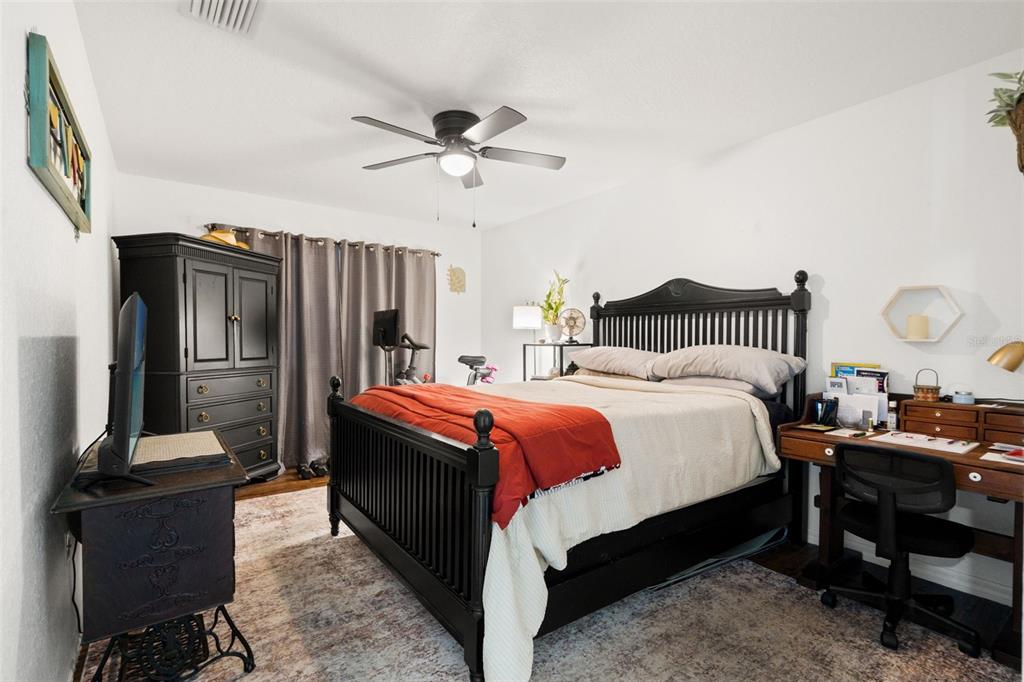 8159 Sturbridge Court, Unit 8159 Weeki Wachee, FL 34613 - Photo 11 of 27 a spacious bedroom with a bed and a chandelier