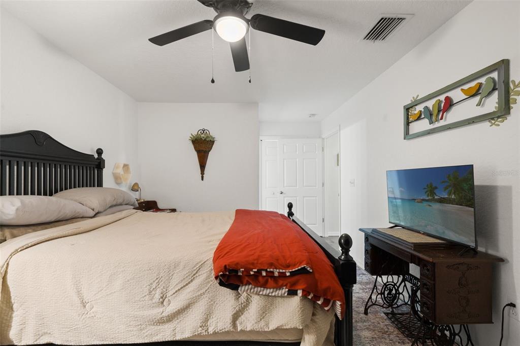 8159 Sturbridge Court, Unit 8159 Weeki Wachee, FL 34613 - Photo 12 of 27 a bedroom with a bed and a flat screen tv